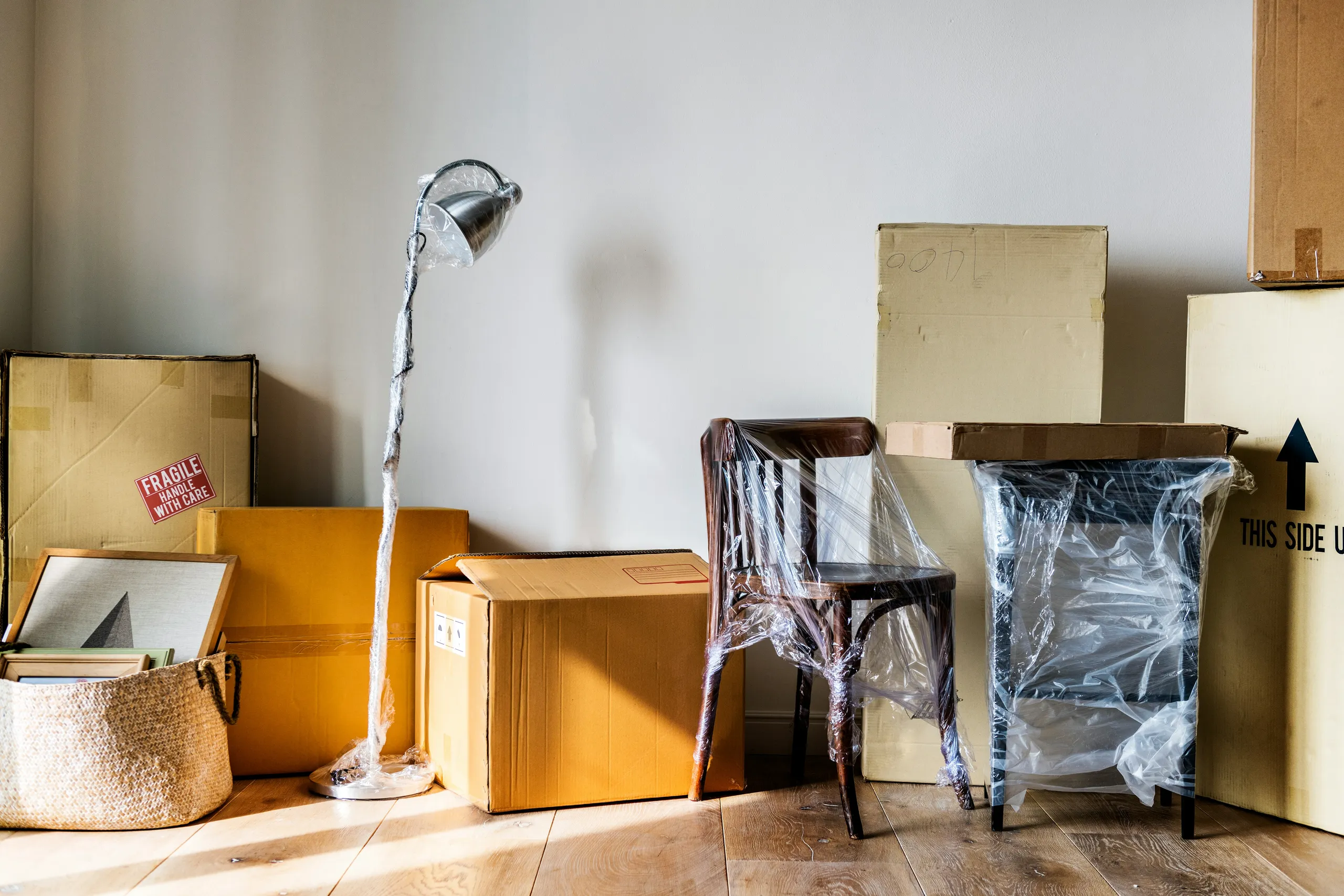 Cajas y muebles empaquetados listos para la mudanza en un piso